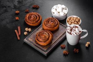 Freshly baked cinnamon roll with spices and cocoa filling on a black background photo