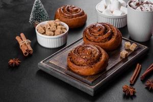 Freshly baked cinnamon roll with spices and cocoa filling on a black background photo