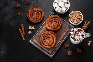 Freshly baked cinnamon roll with spices and cocoa filling on a black background photo