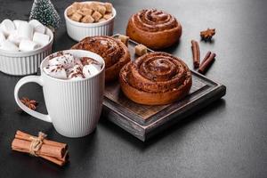Freshly baked cinnamon roll with spices and cocoa filling on a black background photo