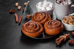 Freshly baked cinnamon roll with spices and cocoa filling on a black background photo