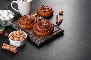Freshly baked cinnamon roll with spices and cocoa filling on a black background photo