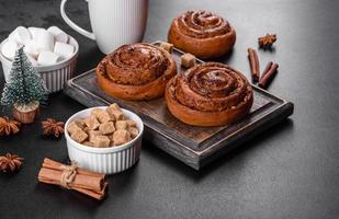 Freshly baked cinnamon roll with spices and cocoa filling on a black background photo