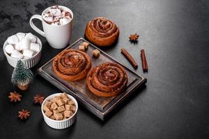 Freshly baked cinnamon roll with spices and cocoa filling on a black background photo