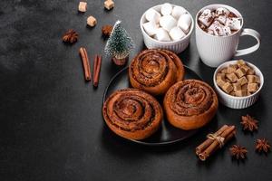 Freshly baked cinnamon roll with spices and cocoa filling on a black background photo