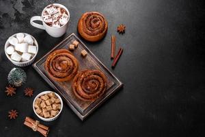 Freshly baked cinnamon roll with spices and cocoa filling on a black background photo