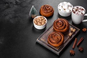 Freshly baked cinnamon roll with spices and cocoa filling on a black background photo