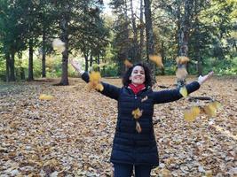 woman throws leaves in the air photo
