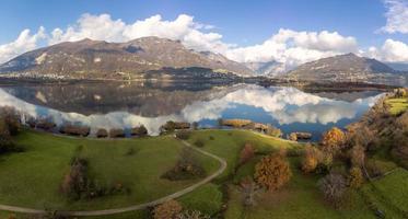 Aerial view of an alpine lake and the surrounding mountains and vegetations reflected photo