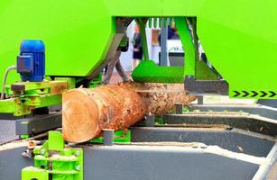 A modern woodworking sawmill quickly and accurately automatically cuts a log, close-up. photo