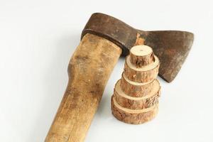 Anillos de madera en el fondo de un viejo hacha sobre un fondo blanco. foto