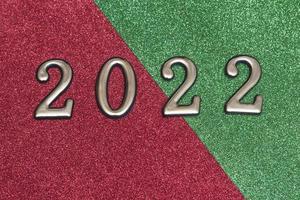 Gold numbers 2022 on a shiny green and red background. photo
