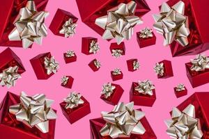 día de boxeo. composición navideña. regalo rojo con lazo dorado sobre fondo rosa. patrón. foto
