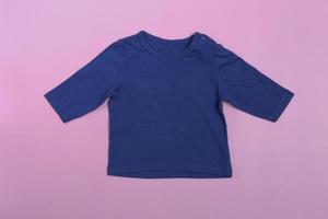 Maqueta de body de bebé con mangas largas en azul sobre fondo rosa.