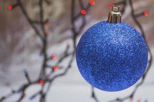 Blue shiny christmas ball isolated on bokeh background photo