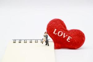 a couple standing on notebook with read heart symbol, idea for valentine background photo