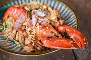 Shellfish seafood plate with lobster dinner food cooked - Grilled Lobster sausage ham vegetables and cheese spaghetti seafood on wooden table photo