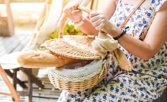 Woman holding baked buns of delicious fragrant bread in basket photo