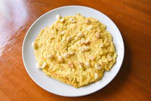 Desayuno de tortilla con nueces de macadamia en la parte superior de la placa blanca comida sana foto