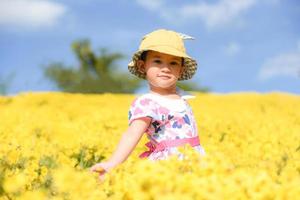 Little asian child girl have fun with a happy smiling face at the morning garden natural flower, Cute girl children kids playing outside on bright day beautiful flower in spring outdoors photo