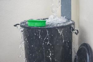 Cubo con salpicaduras de agua cosecha de agua de lluvia en el cubo de agua después de la lluvia foto