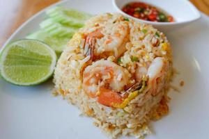 fried rice shrimp seafood lime and cucumber on plate wooden table from top view, thai food. photo