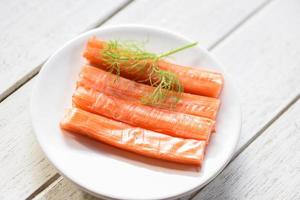 Crab sticks on white plate and vegetable , Fresh crab sticks surimi ready to eat japanese food. photo