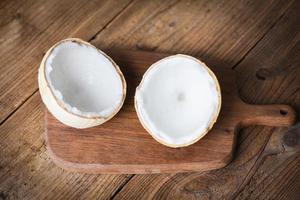 cut half coconut and fresh coconuts on old wooden table for food. photo