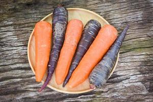 zanahoria y zanahoria morada en bandeja, zanahoria fresca para cocinar vegetariano en mesa de madera en la cocina. foto