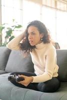 mujer laitina jugando videojuegos con las manos sosteniendo el joystick foto