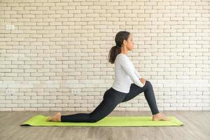 Latin woman practicing yoga on mat photo