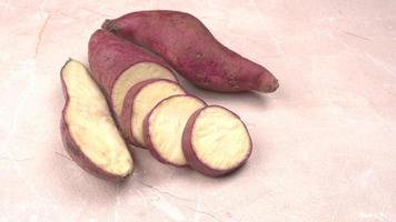 slices of sweet potatoes on wooden background, close up. Raw sweet potatoes or batatas. photo