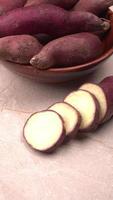 slices of sweet potatoes on wooden background, close up. Raw sweet potatoes or batatas. photo