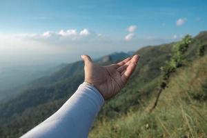 Hands outstretched to receive natural light and mountain views photo