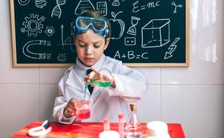 Serious kid playing with chemical liquids photo