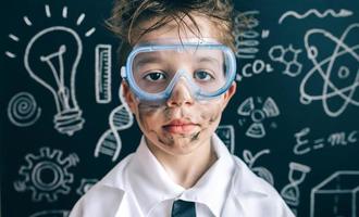 Little chemist in glasses looking seriously at camera photo