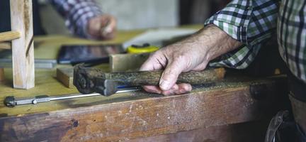 Carpenter's hand holding a hammer photo