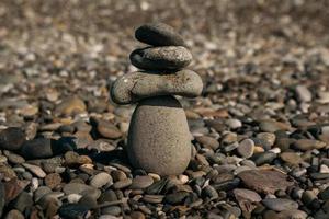 Stones pyramid on pebble beach symbolizing stability, zen, harmony, balance photo