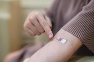 pregnant woman draws blood from an injection wound on a patient's arm. photo