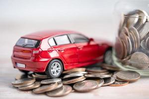 coche sobre fondo de monedas conceptos de préstamo de coche, finanzas, ahorro de dinero, seguros y tiempo de arrendamiento. foto