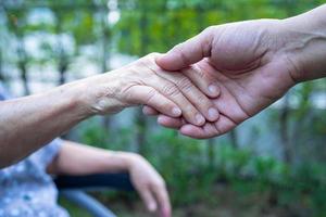 Holding hands Asian senior or elderly old lady woman patient with love, care, encourage and empathy at nursing hospital ward, healthy strong medical concept photo