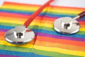 Red stethoscope on rainbow flag background, symbol of LGBT pride month  celebrate annual in June social, symbol of gay, lesbian, bisexual, transgender, human rights and peace. photo