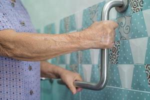 Asian senior or elderly old lady woman patient use toilet bathroom handle security in nursing hospital ward, healthy strong medical concept. photo