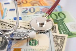 Stethoscope on US dollar and Euro banknotes, Finance, Account, Statistics, Analytic research data and Business company  medical health meeting concept photo