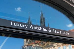 Relojes de lujo y carteles de joyería fuera de un escaparate de vidrio foto