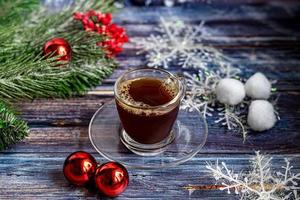 una taza de café aromático con azúcar morena, adornos navideños, ramas de un árbol de navidad. concepto de vacaciones año nuevo. sobre un fondo de madera. foto