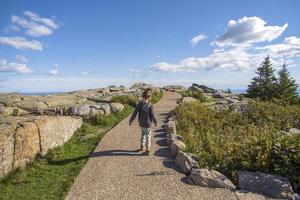 Little girl walking on a stone path on a mountain photo