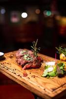 Entrecote Beef Grilled steak meat on wooden cutting boardon with rosemary branch, pepper and salt . photo