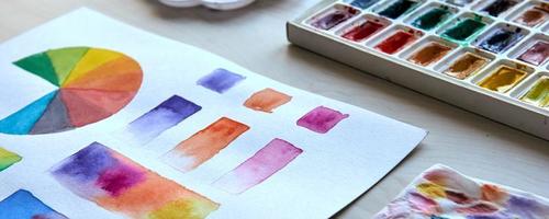 Artist's workplace. Art supplies brushes, paints, watercolors. Art studio. Drawing lessons. Creative workshop. Design place. Watercolor color wheel and palette. Color theory beginner hobby lessons photo