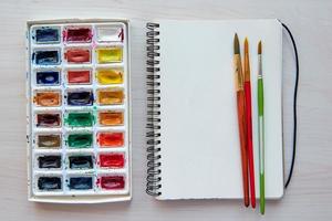 Art supplies brushes, watercolor paints, sketchbook. Artist's workplace. Creative Drawing workshop. photo